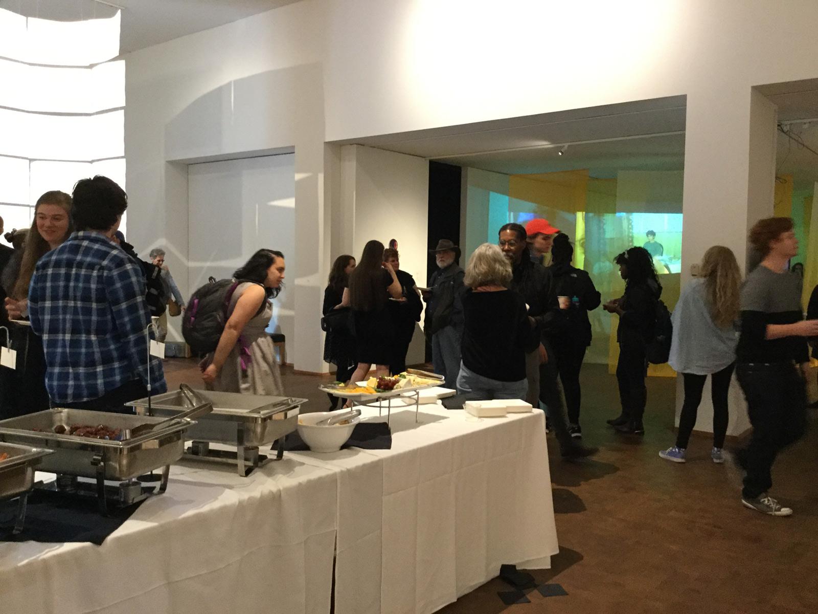 gallery patrons hover twixt fine art and the chafing dishes on the buffet