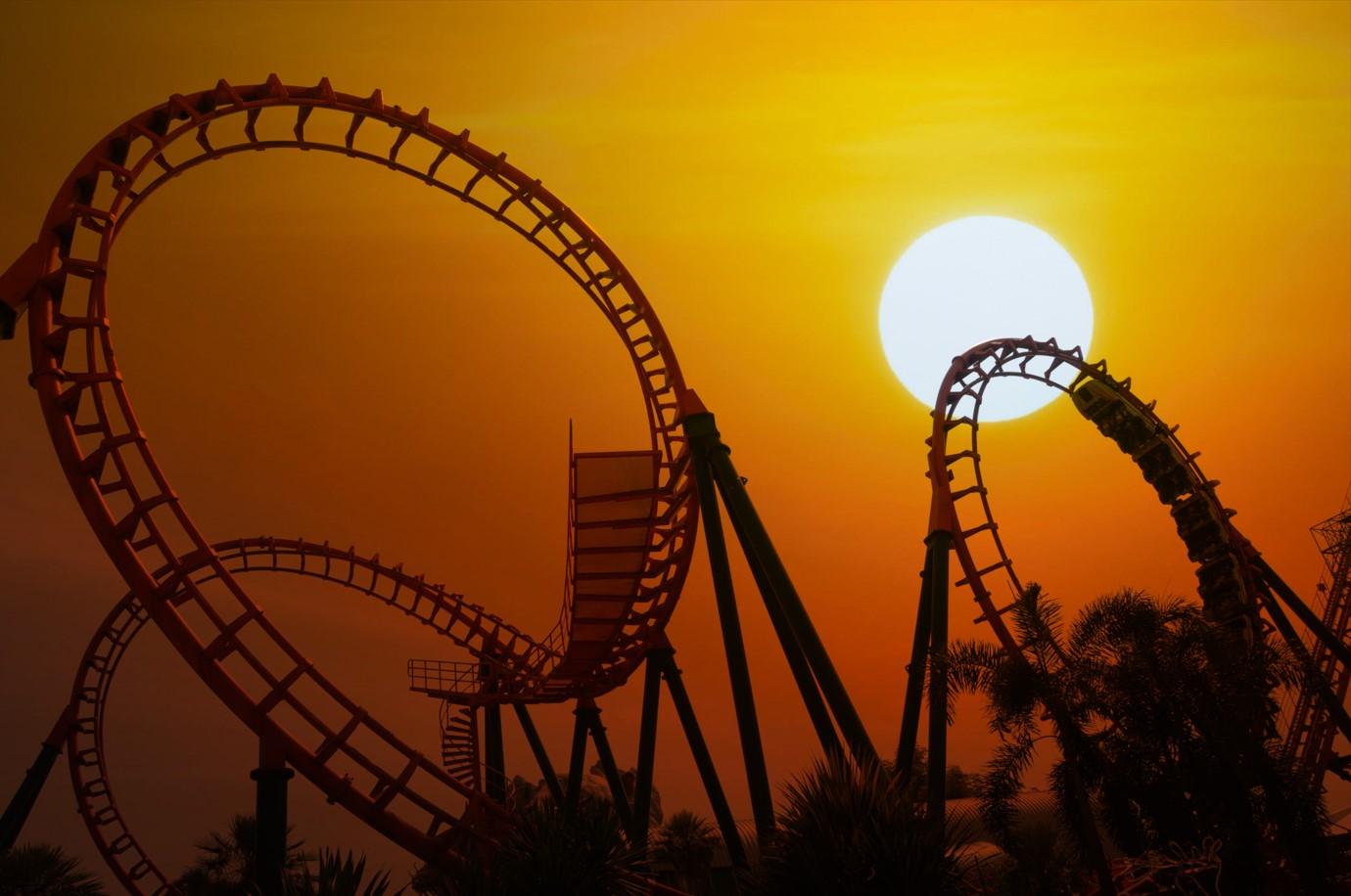 large unoccupied roller coaster silhouetted against an eerie sunset