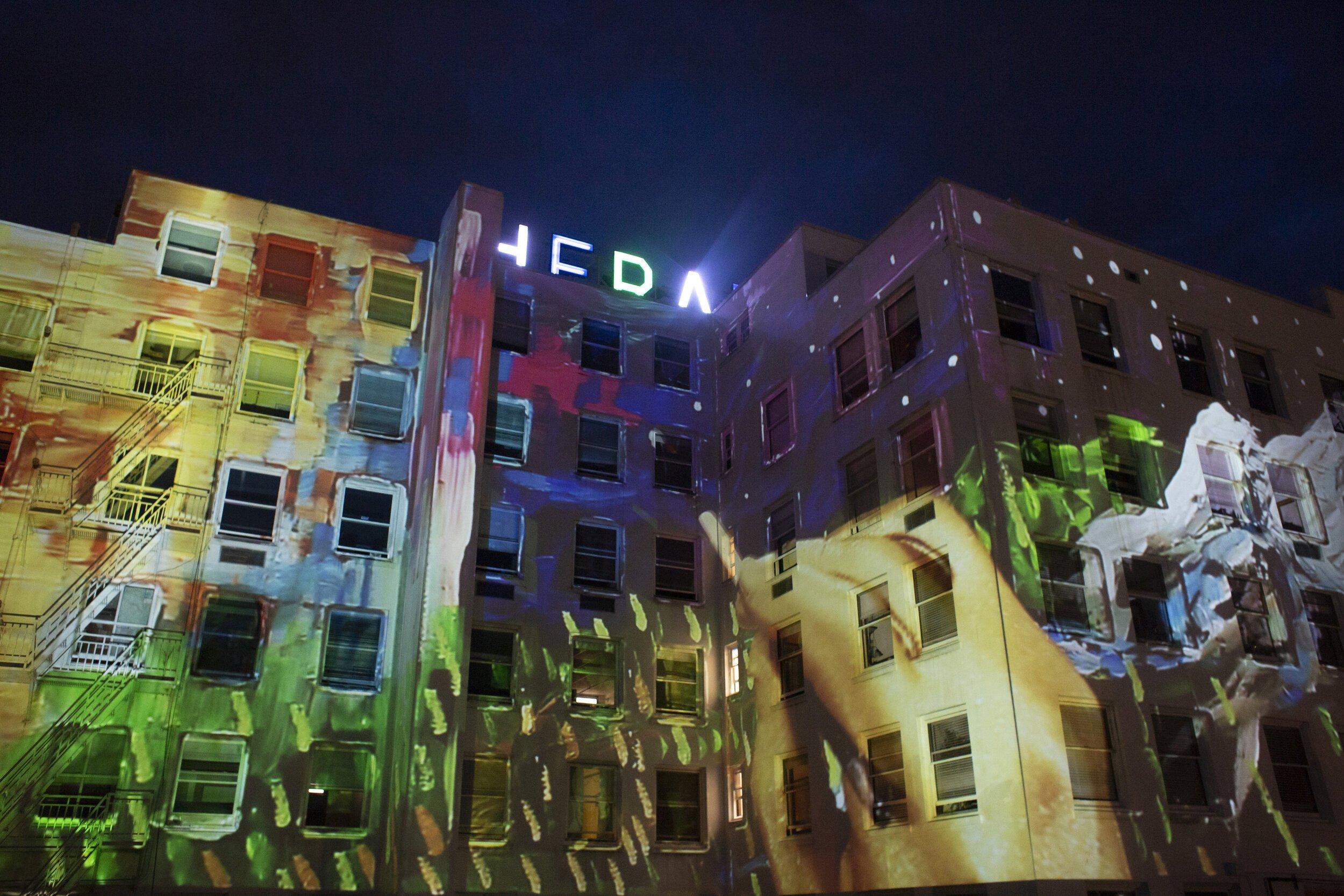 colorful paint strokes projected onto the entire front of the Herald building