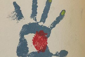 blue handprint with red anatomical heart in the palm