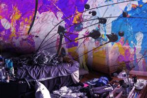 very messy room with intense splotches of color on the walls