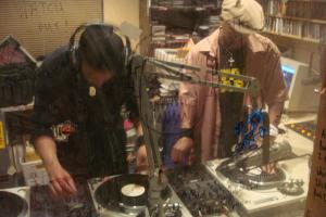 Two hip hop DJs creating new music by mixing tracks from multiple record players