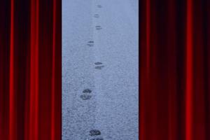 between theatre curtains appears fresh footprints on a snowy road