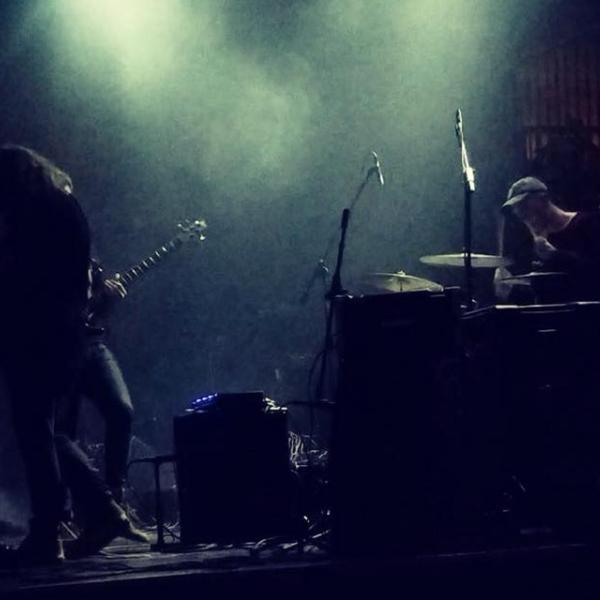 a rock band on a murky stage with moody lighting