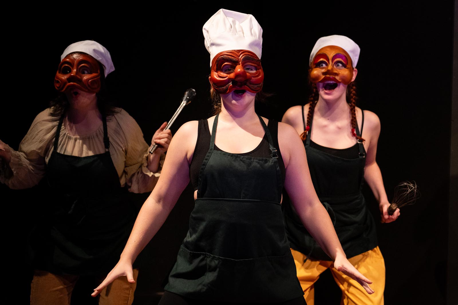 three masked perfomers in chef hats