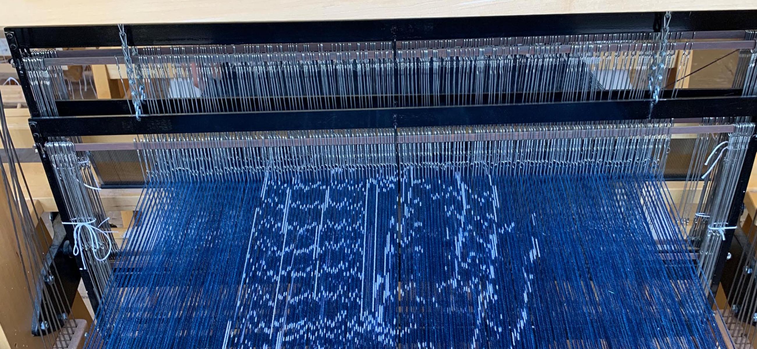 a loom with blue fabric and thread